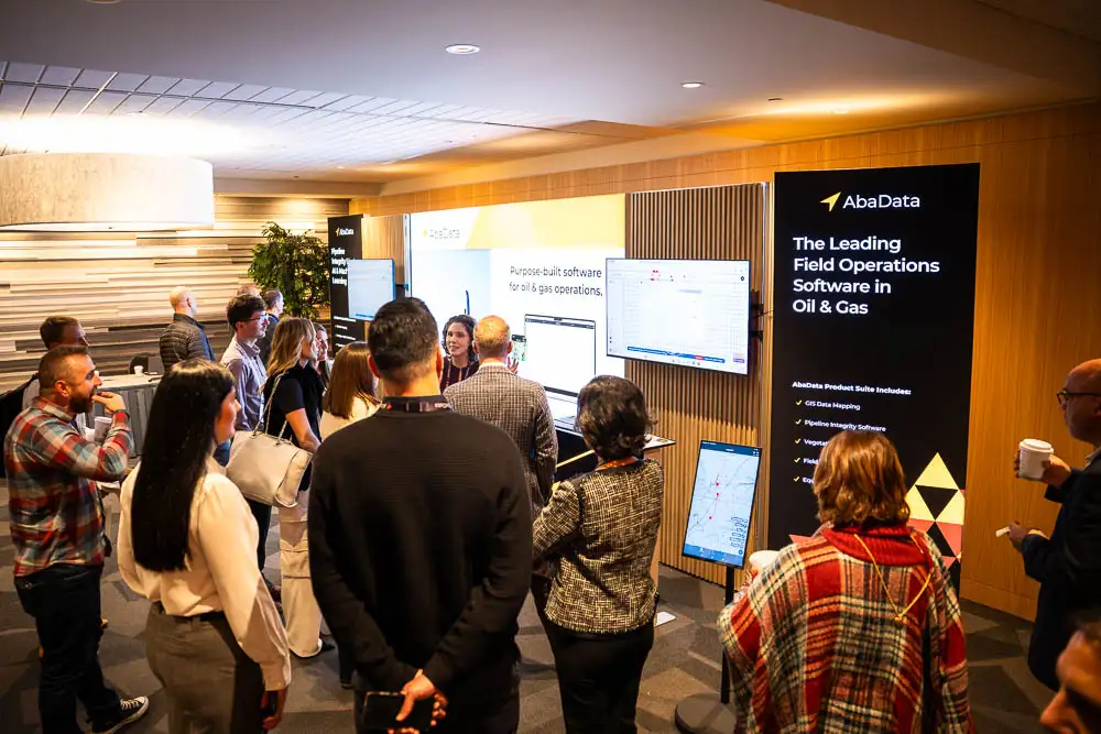 AbaData User Conference 2025 Images (10 of 20) with full crowd of people around our bright AbaData booth receiving a demonstration of latest AbaData software and features